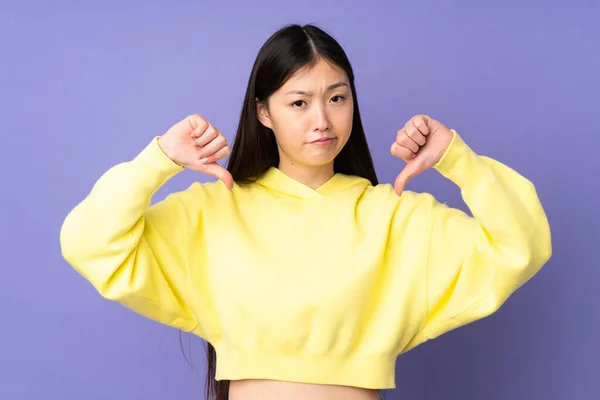 Joven Asiático Mujer Aislado Púrpura Fondo Mostrando Pulgar Hacia Abajo —  Fotos de Stock
