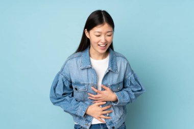 Genç Asyalı kadın arka planda izole edilmiş, gülümsüyor.