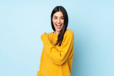 Mavi arka planda izole edilmiş beyaz bir kadın zaferi kutluyor.