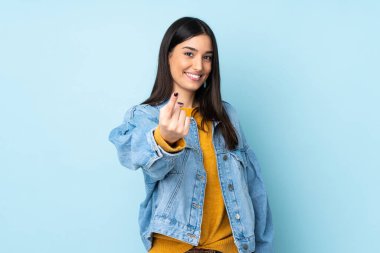 Mavi arka planda izole genç beyaz kadın geliyor.