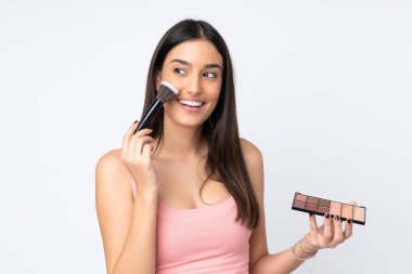 Beyaz arka planda makyajlı ve mutlu beyaz bir kadın.