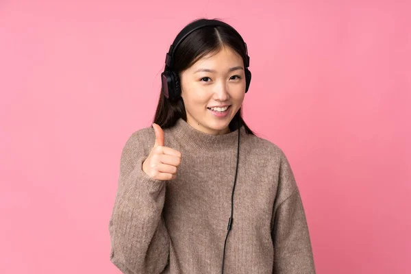 Genç Asyalı Bir Kadın Pembe Arka Planda Izole Edilmiş Müzik — Stok fotoğraf