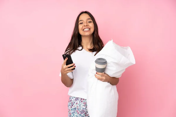 Jovem Pijama Isolado Fundo Rosa Segurando Café Para Levar Celular — Fotografia de Stock