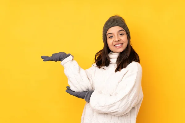 Jovem Com Chapéu Inverno Sobre Fundo Amarelo Isolado Estendendo Mãos — Fotografia de Stock