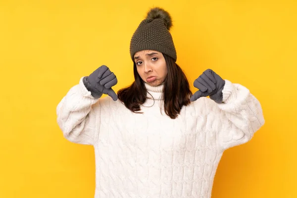 Giovane Donna Con Cappello Invernale Sfondo Giallo Isolato Mostrando Pollice — Foto Stock