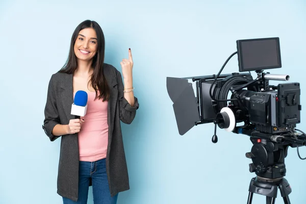 Mulher Repórter Segurando Microfone Reportando Notícias Isoladas Fundo Azul Apontando — Fotografia de Stock