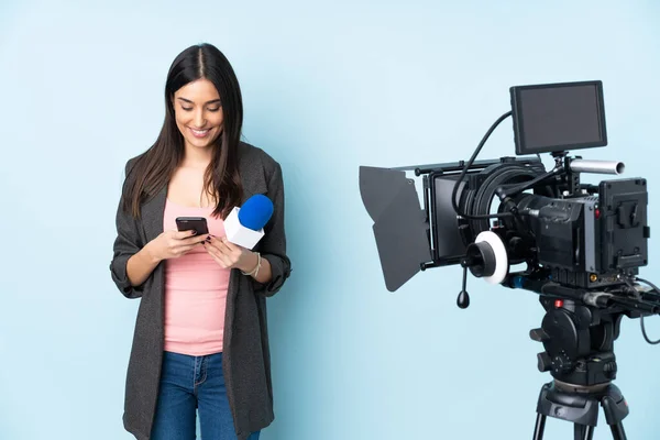 Mulher Repórter Segurando Microfone Reportando Notícias Isoladas Fundo Azul Enviando — Fotografia de Stock