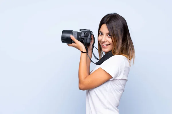 Zole Edilmiş Mavi Arka Planda Profesyonel Kameralı Genç Bir Kadın — Stok fotoğraf