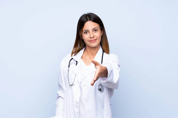 Jovem Mulher Sobre Fundo Azul Isolado Com Vestido Médico Fazer — Fotografia de Stock