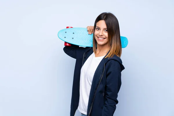 Jovem Mulher Sobre Isolado Fundo Azul Com Skate — Fotografia de Stock
