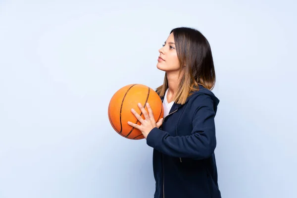 Mladá Žena Nad Izolované Modré Pozadí Míčem Basketbalu — Stock fotografie