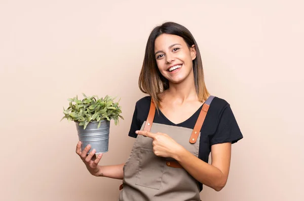 Jonge Vrouw Die Een Plant Vasthoudt Aanwijst — Stockfoto