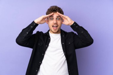 Mor arka planda, sürpriz bir ifadeyle izole edilmiş beyaz bir adam.