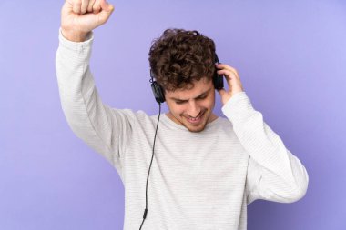 Beyaz adam mor arka planda izole edilmiş müzik ve dans dinliyor.