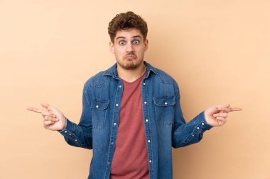 Beyaz adam bej arka planda izole edilmiş. Yan taraftakilerin şüpheleri var.