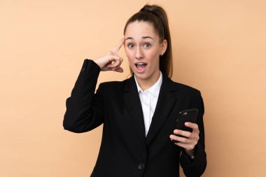 Çözümü bulmak için cep telefonu kullanan genç bir iş kadını.