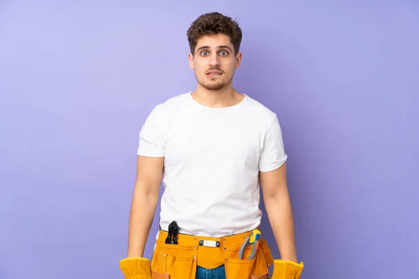 Jovem Eletricista Homem Mais Isolado Fundo Roxo Com Dúvidas Com — Fotografia de Stock