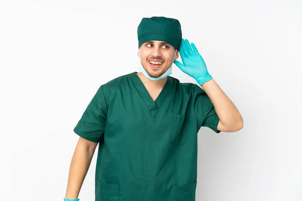 Cirujano Uniforme Verde Aislado Sobre Fondo Blanco Aislado Escuchando Algo — Foto de Stock