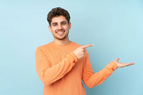 Blanke Man Geïsoleerd Blauwe Achtergrond Met Denkbeeldige Copyspace Palm Een — Stockfoto