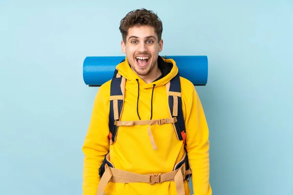 Joven Montañero Con Una Gran Mochila Aislada Sobre Fondo Azul — Foto de Stock