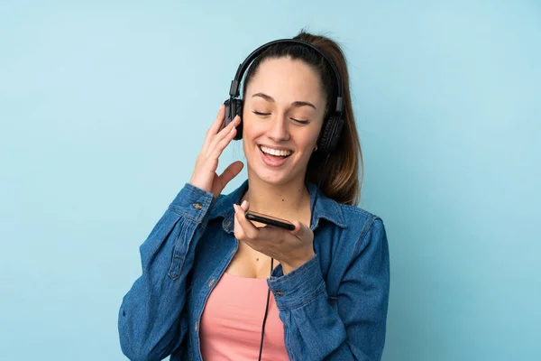 Ung Brunett Kvinna Över Isolerad Blå Bakgrund Lyssna Musik Med — Stockfoto