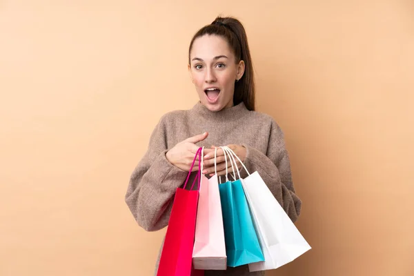 Joven Morena Sobre Fondo Aislado Sosteniendo Bolsas Compras Sorprendida — Foto de Stock