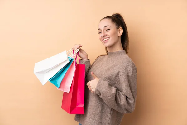 Jong Brunette Vrouw Geïsoleerde Achtergrond Holding Shopping Tassen Met Duim — Stockfoto