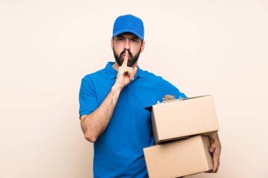 Arka planda sakallı bir teslimatçı sessizce hareket ettiğini gösteriyor. Parmağını ağzına sokuyor.