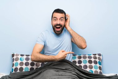 Yataktaki adam şaşırdı ve parmağını yana çevirdi.