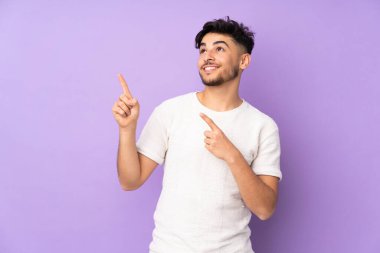 İzole edilmiş arka plan üzerinde yakışıklı Arap bir adam işaret parmağıyla işaret etmek harika bir fikir.