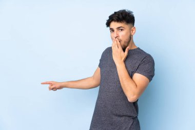 Bir yandan işaret ederken diğer yandan sürpriz bir ifadeyle yalıtılmış arap yakışıklı adam.