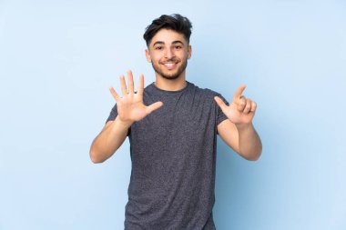 İzole edilmiş arka planda yaşayan Arap yakışıklı adam parmaklarıyla yediyi saydı.