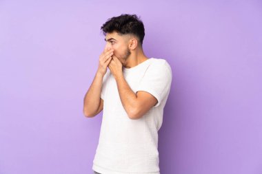 Arap yakışıklı adam izole edilmiş arka planda ağzını kapatıyor ve yana bakıyor.