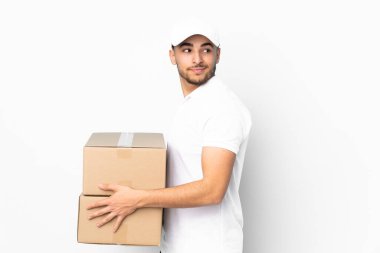 Teslimat yapan Arap adam mavi arka planda izole edilmiş gülüyor.