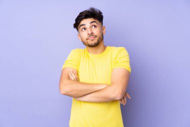 Münzevi bir geçmişi olan Arap yakışıklı bir adam omuzlarını kaldırırken şüphe jesti yapıyor.