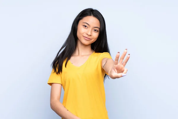 Έφηβη Κινέζα Απομονωμένη Μπλε Φόντο Χαρούμενη Και Μετρώντας Τρία Δάχτυλα — Φωτογραφία Αρχείου