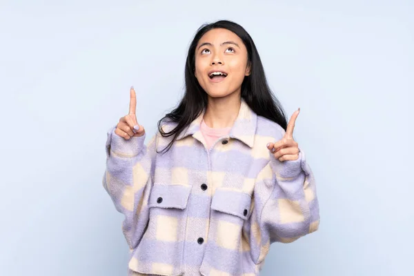 Adolescente Chinesa Mulher Isolada Fundo Azul Surpreso Apontando Para Cima — Fotografia de Stock