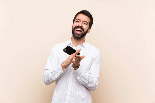 Junger Mann Mit Bart Hält Ein Handy Der Hand Und — Stockfoto