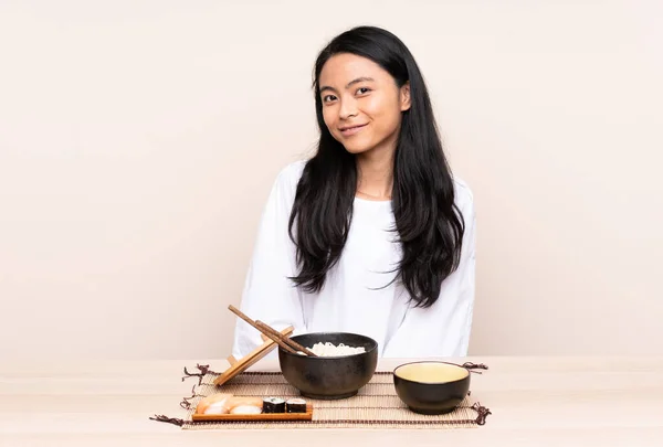 Tiener Aziatisch Meisje Eten Aziatisch Eten Geïsoleerd Beige Achtergrond Lachen — Stockfoto