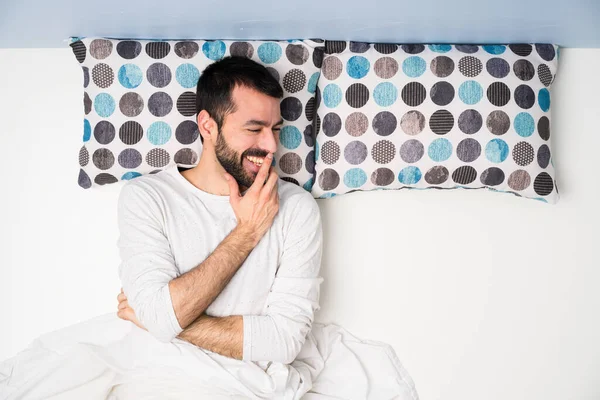 Man in bed in top view smiling a lot