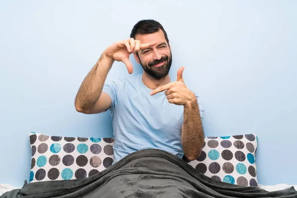 Man in bed focusing face. Framing symbol