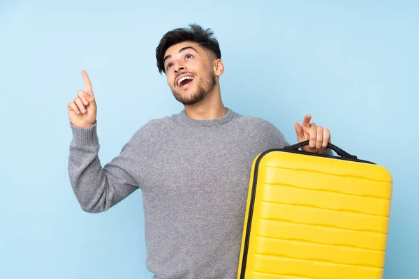 Arabische Knappe Man Geïsoleerd Blauwe Achtergrond Vakantie Met Reiskoffer Wijzen — Stockfoto