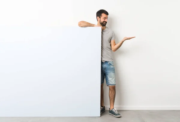 Jovem Homem Bonito Com Barba Segurando Grande Cartaz Azul Vazio — Fotografia de Stock