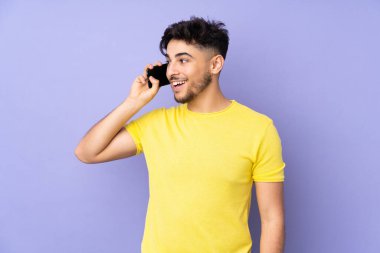 Arap yakışıklı adam izole edilmiş arka planda cep telefonuyla sohbet ediyor.