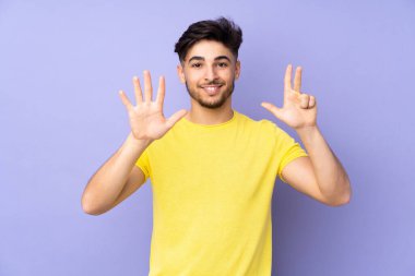 İzole edilmiş arka planda yaşayan Arap yakışıklı adam parmaklarıyla sekiz kişi sayıyor.