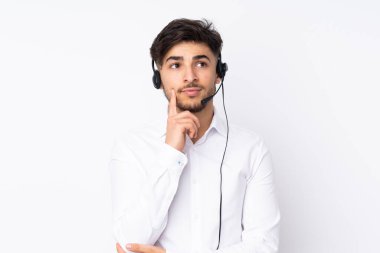 Tele pazarlamacı Arap bir adam beyaz arka planda izole edilmiş bir kulaklıkla çalışıyor.