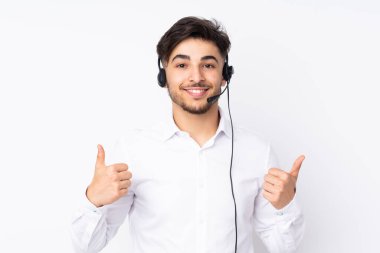 Tele pazarlamacı Arap bir adam beyaz arka planda izole edilmiş bir kulaklıkla çalışıyor.