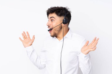 Tele pazarlamacı Arap bir adam beyaz arka planda yüz ifadesi ile izole edilmiş bir kulaklıkla çalışıyor.