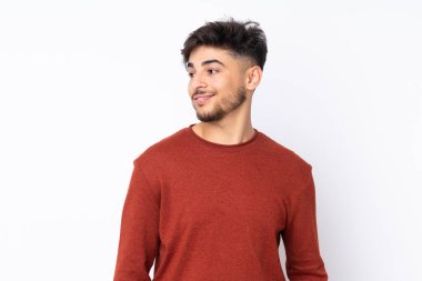 Münzevi bir geçmişi olan yakışıklı Arap bir adam yana bakıyor ve gülümsüyor.