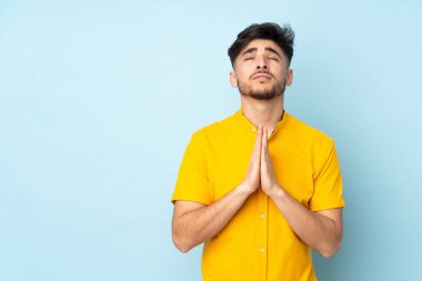 Soyutlanmış geçmişi olan Arap yakışıklı bir adam avuç içlerini bir arada tutar. İnsan bir şey ister.